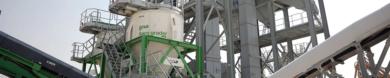 A green CFlo Aerograder air classifier on a steel gantry, feeding a conveyor beneath it