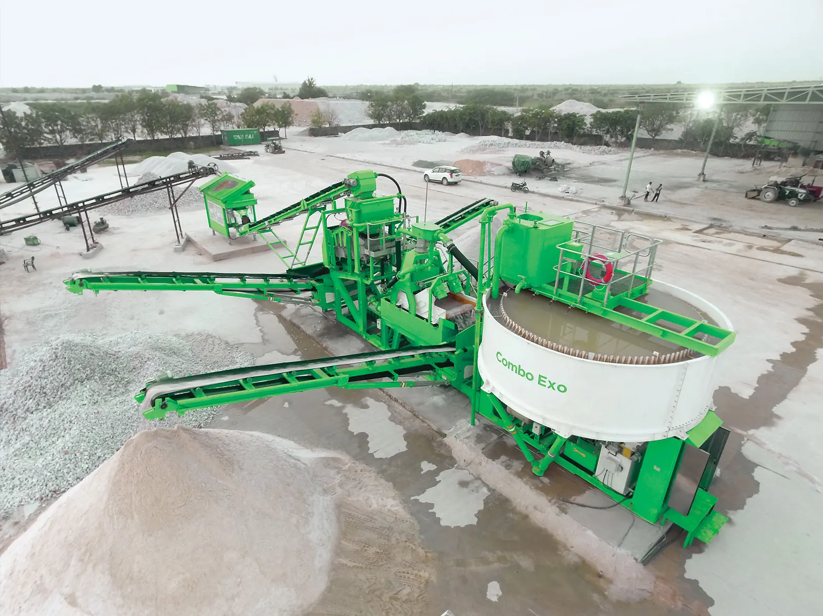 Aerial view of a green CFlo plant with a circular thickener tank, conveyors and pale stockpiles
