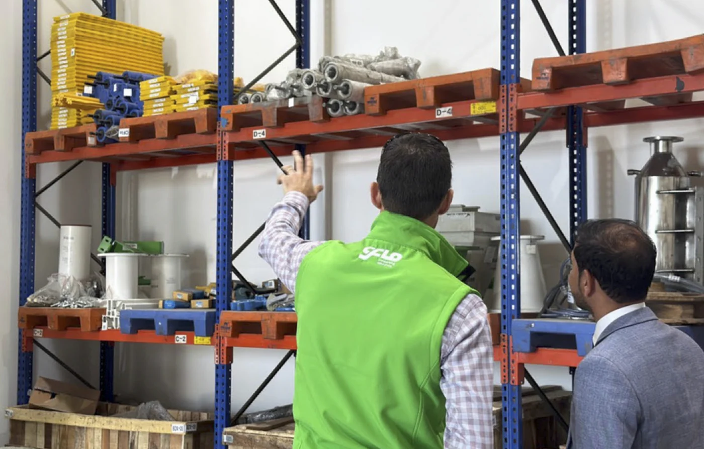 A CFlo engineer showing racked spare parts and consumables to a visiting customer