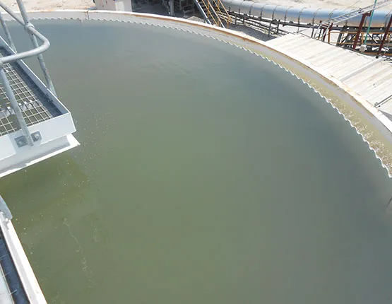 Looking down into a large circular thickener tank holding green process water