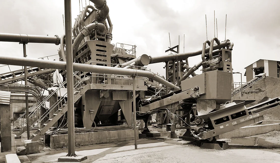 Plant pipework, cyclones and chutes seen from below against a bright sky