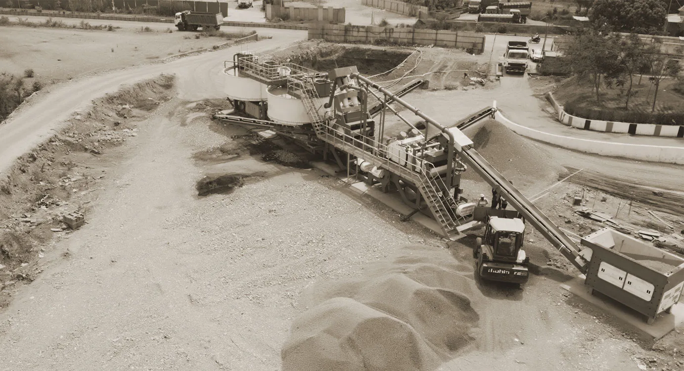 Aerial view of a plant working over pale sand with haul roads around it