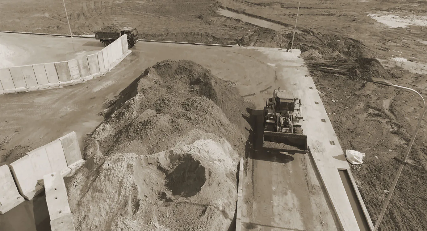 Looking down on a washing plant set into an excavated bay with sand around it