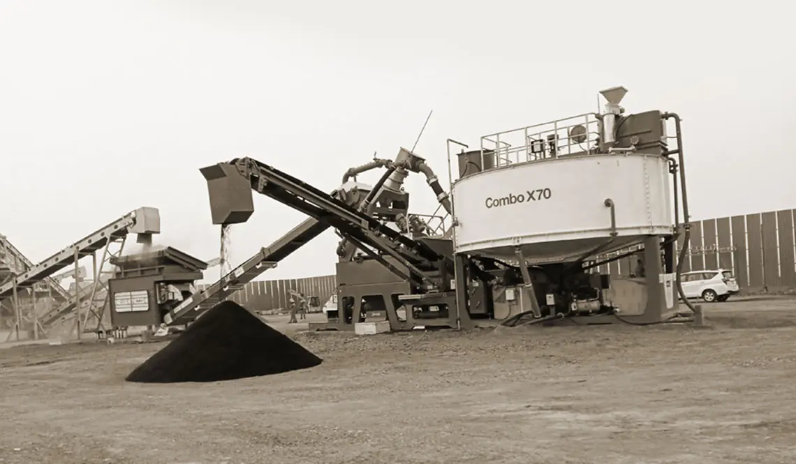 A CFlo Combo X70 unit on site, conveyors feeding a dark conical stockpile
