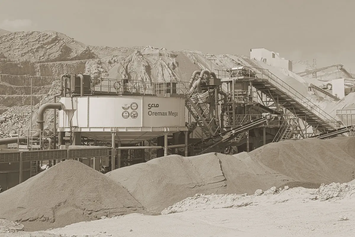 A CFlo Oremax unit working beside long pale stockpiles below a quarry face