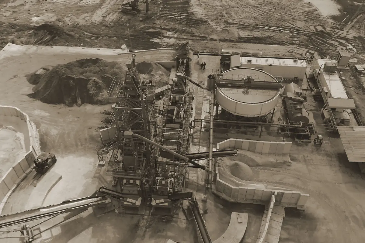Aerial view of a plant with a circular thickener, conveyors and excavated ground