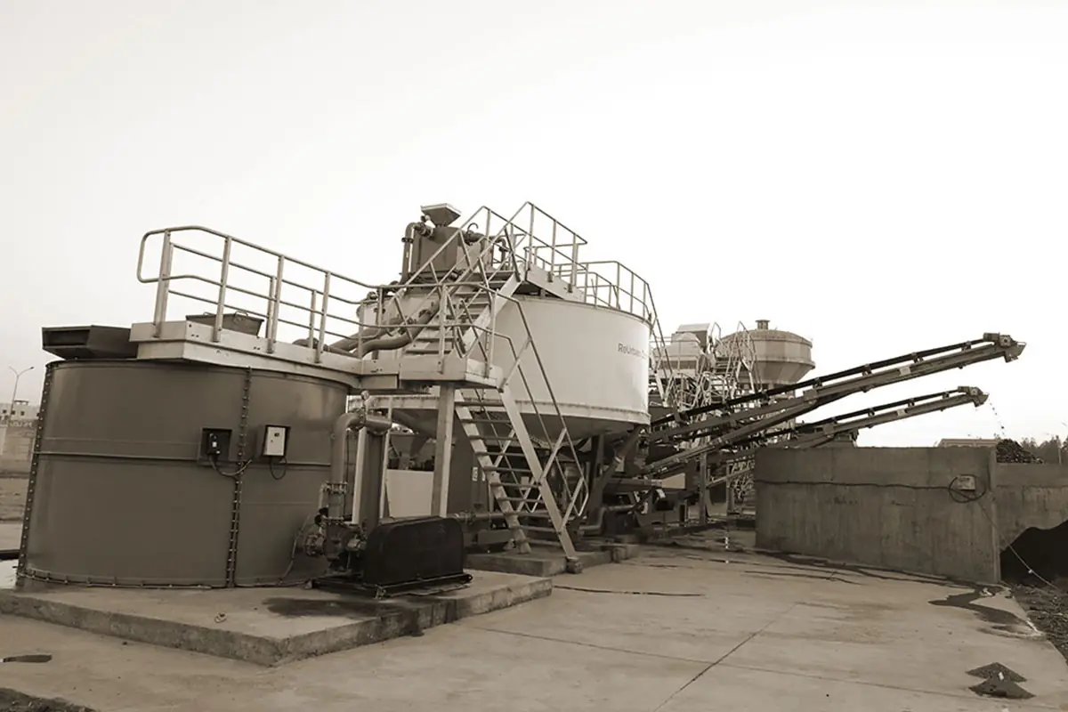 A compact plant with walkways and a feed conveyor on a concrete pad