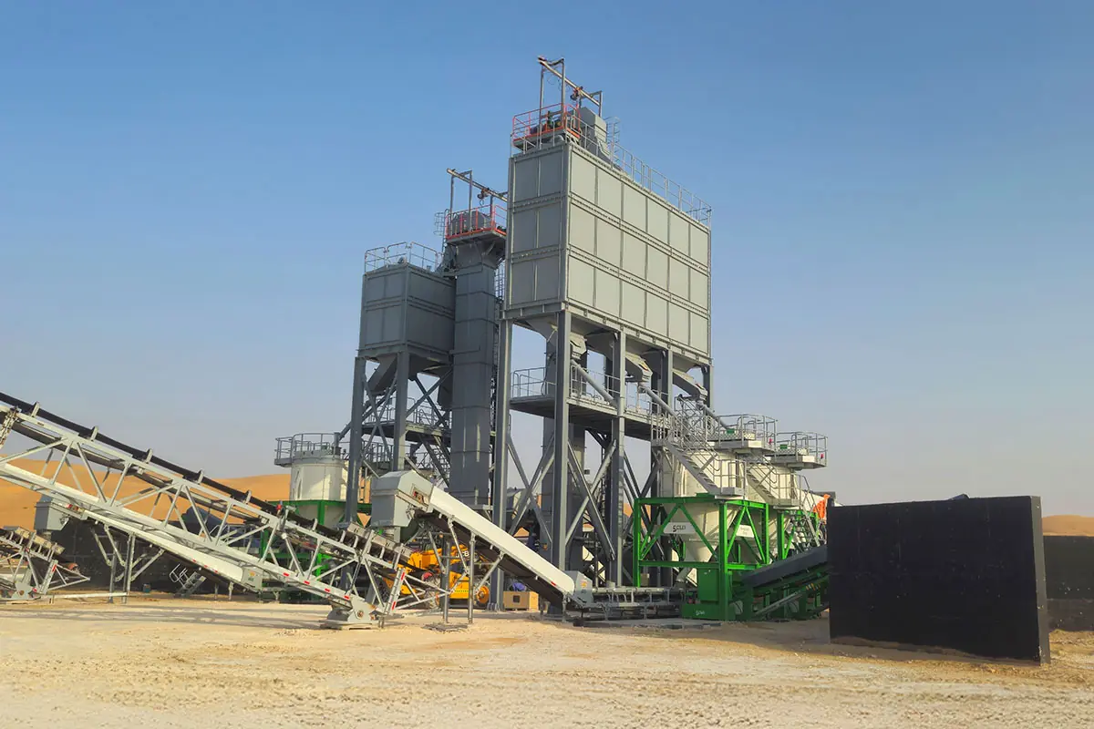 A green CFlo plant beside a tall grey silo tower on a desert site