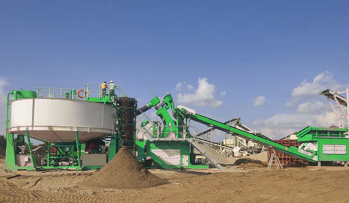 A green CFlo plant with a circular tank discharging graded sand under a blue sky