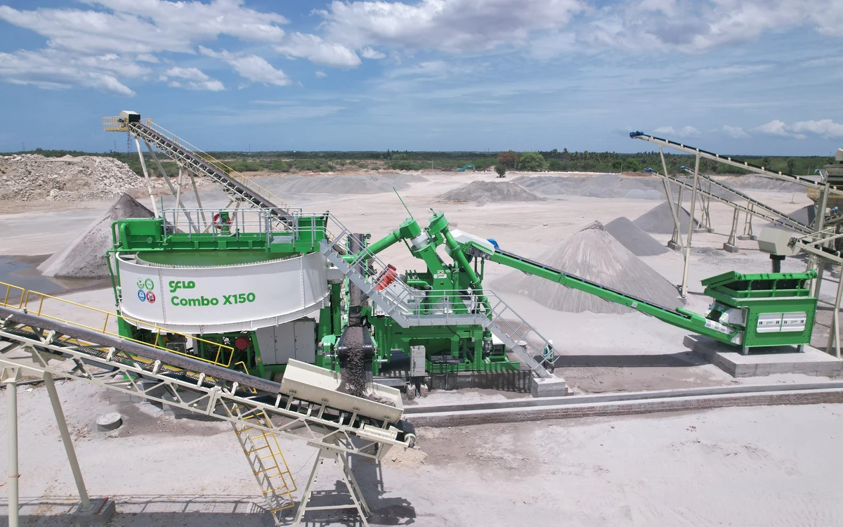 CFlo Combo X150 producing manufactured sand in a quarry, the white thickener tank on the left, crusher dust arriving on the feed conveyor and washed sand discharging to a conical stockpile