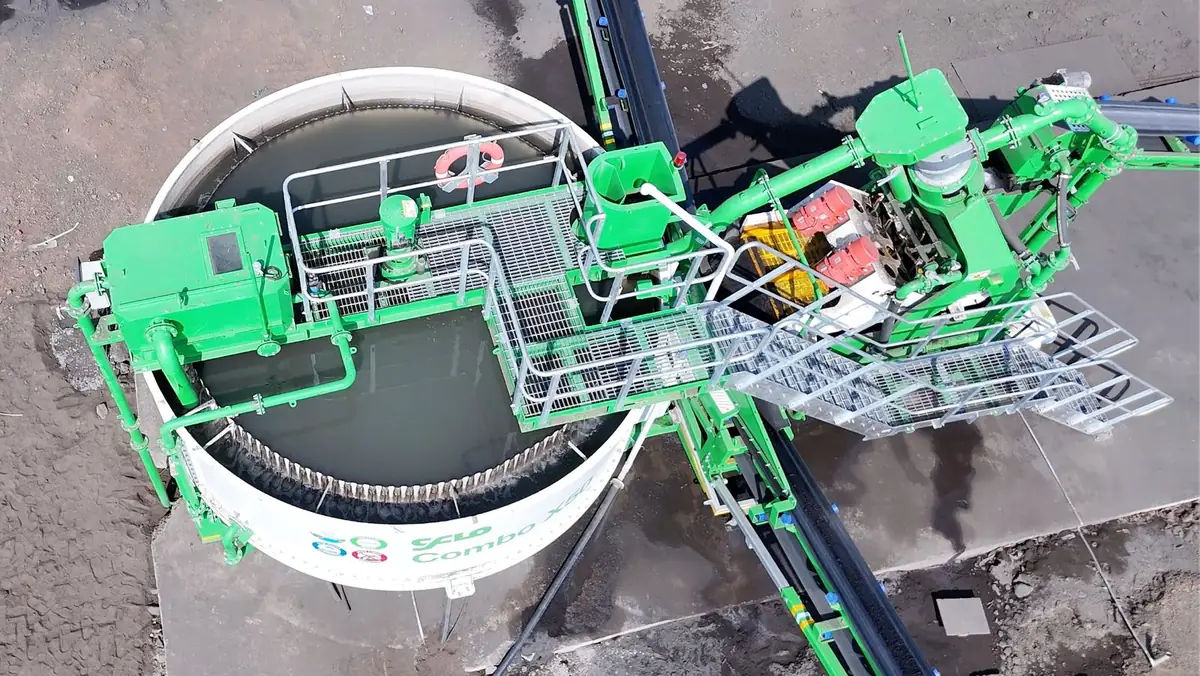 Overhead view of the white Hydromax thickener tank built into a green CFlo Combo, its V-notch overflow weir running round the rim and the galvanised access bridge and walkway crossing the tank