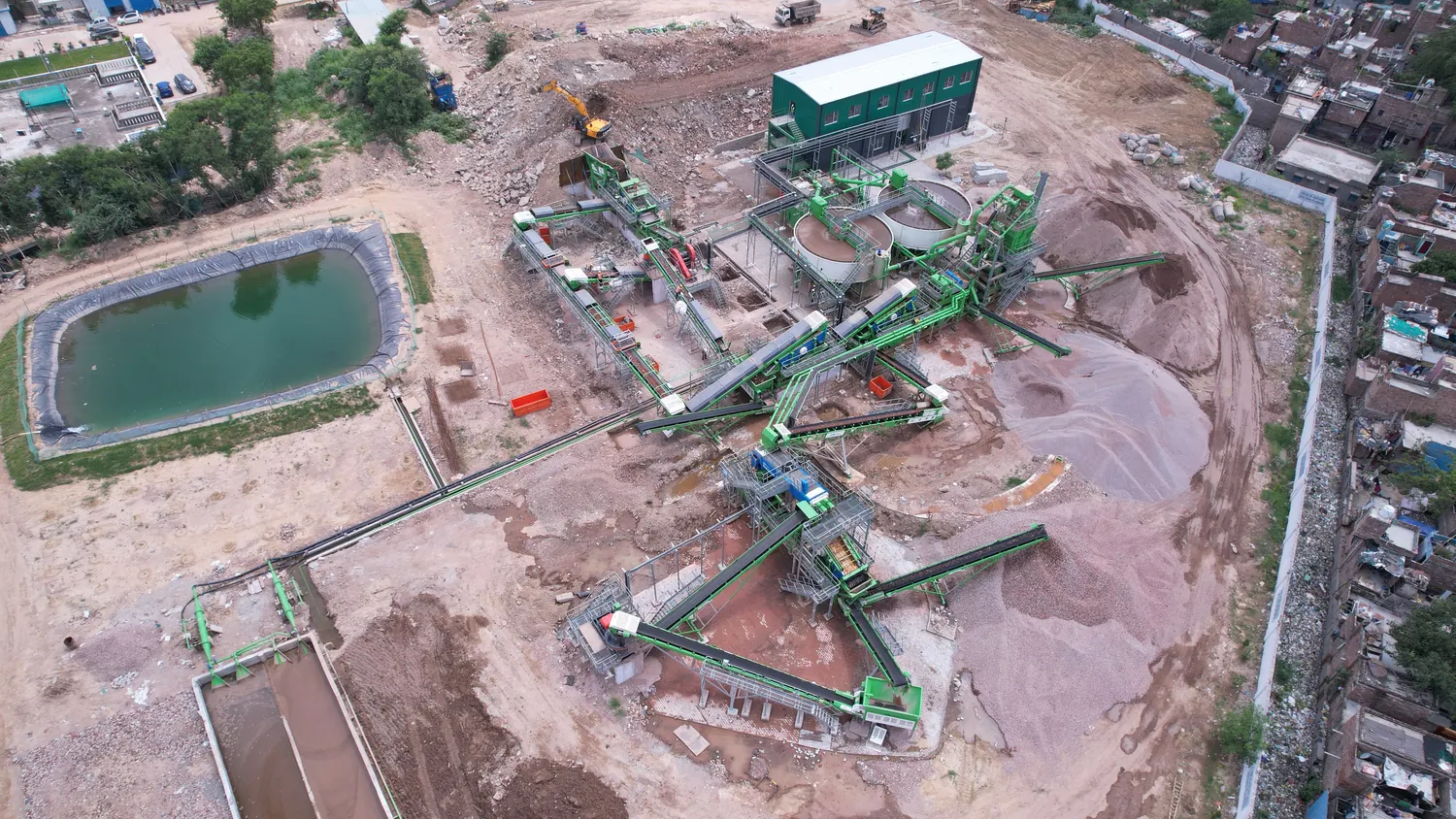 Aerial view of the whole Burari site in Delhi, showing the Reurban plant, its stockpiles and the lined water pond, operating inside the city it serves