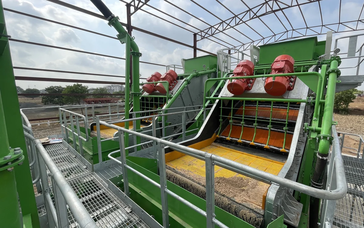 Two Screenmax FS86 High Precision Fines Screens working side by side in a plant, red twin exciters above each stepped deck and washed sand discharging from the dewatering panels onto the conveyors below