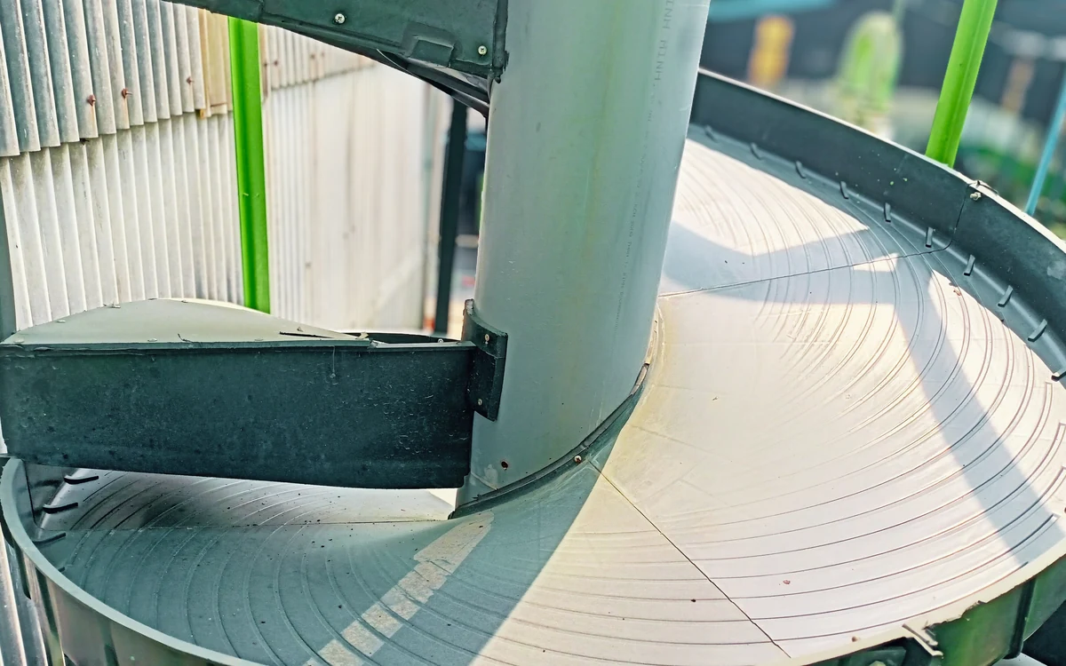 Close-up of the top of a Spiropure spiral, the helical trough winding around its central column with the polyurethane wear surface and the concentric wear lines left by the slurry running down it