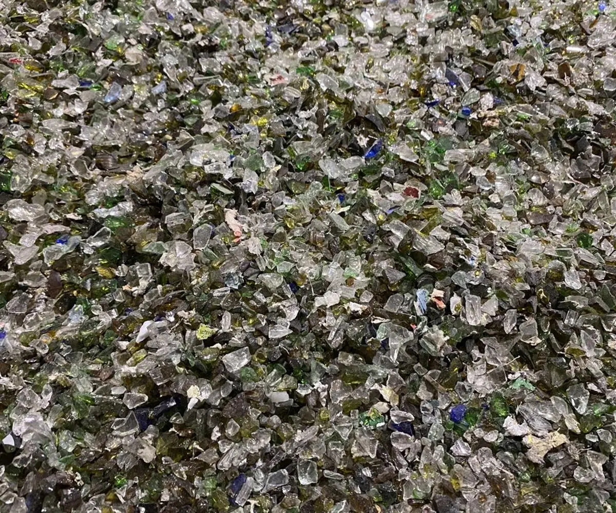 Close-up of crushed recycled glass cullet in mixed greens and browns
